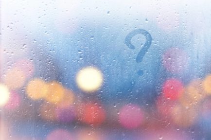Rainy window pane with a question mark, depicting public cloud managed services FAQ